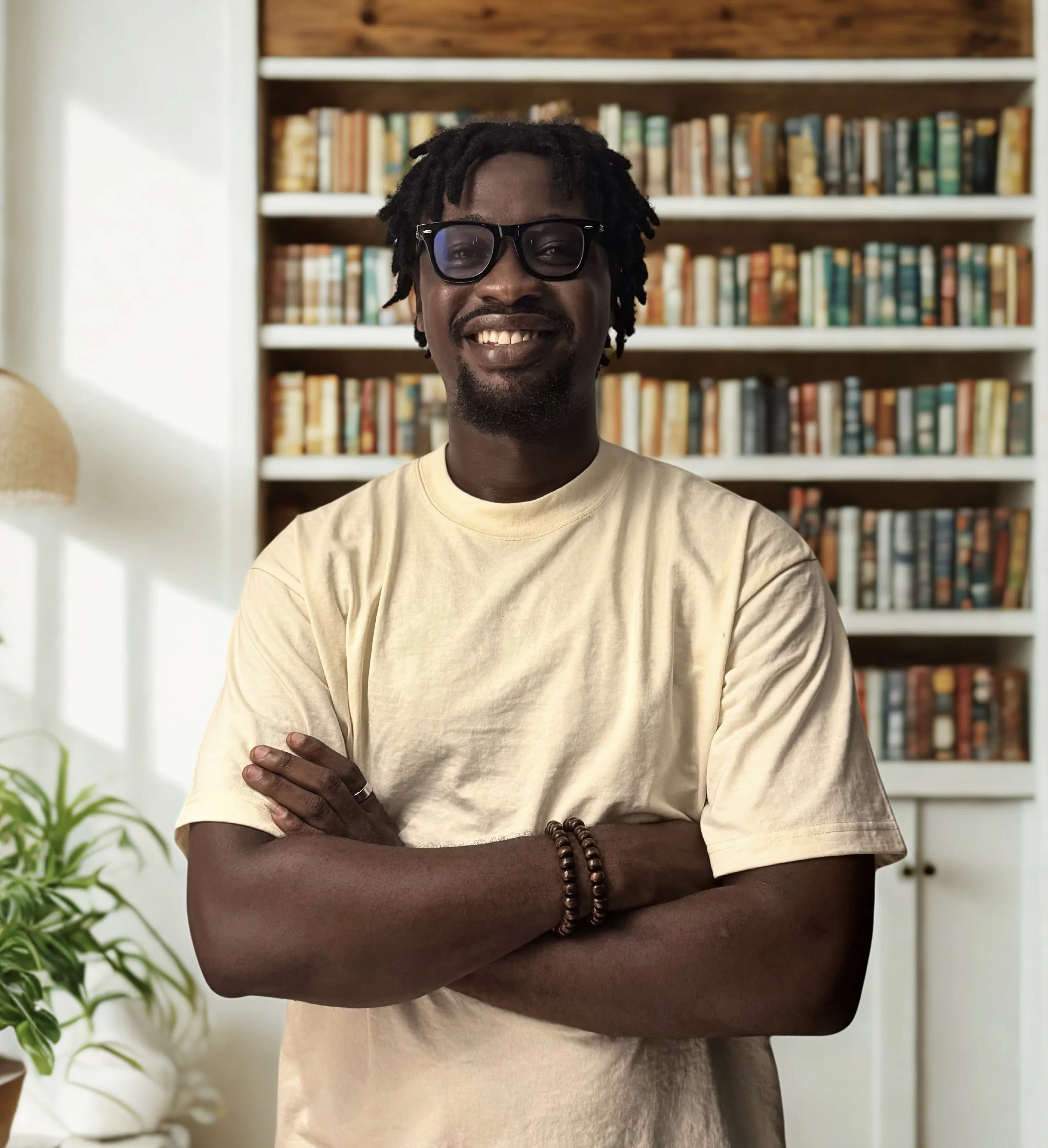 Prince Francix, founder of Monarch Tales, standing in front of bookshelves