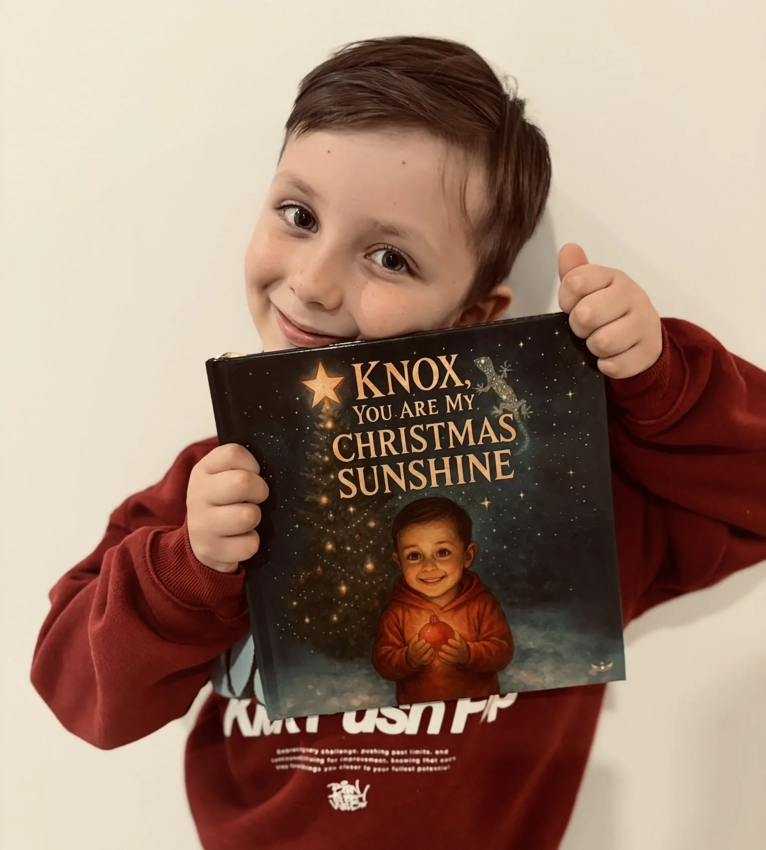 Knox smiling and holding the finished personalised Monarch Tales book made for him