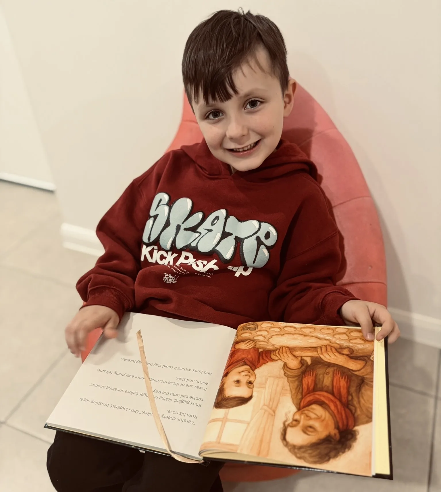 Knox with an open Monarch Tales book showing its illustrated interior