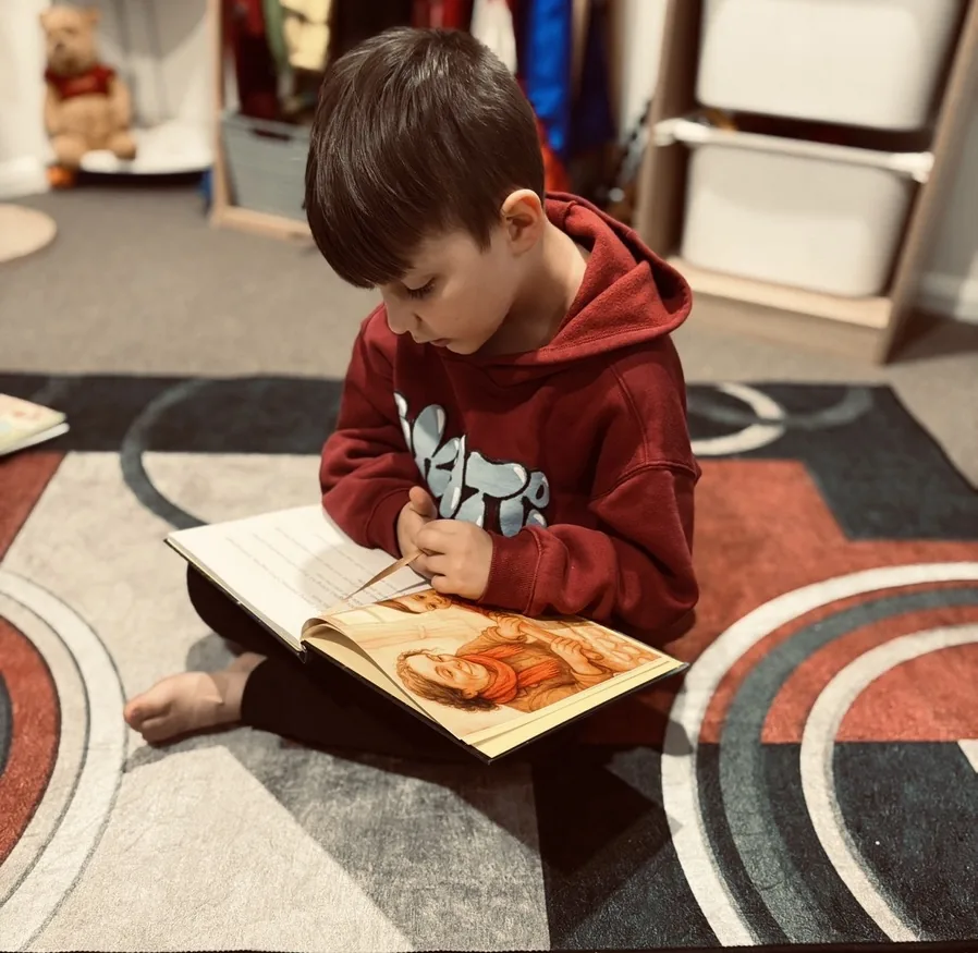 Knox sitting and reading his personalised storybook